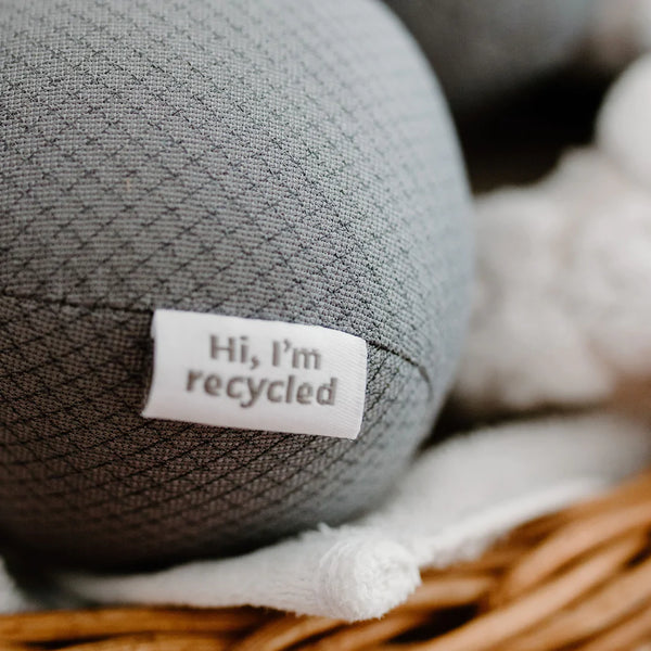 three antistatic vegan dryer balls made from recycled plastic water bottles. Color gray, sitting on top of white towels in a basket. three antistatic vegan dryer balls made from recycled plastic water bottles. Color gray, sitting on top of white towels in a basket.