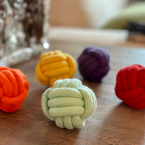 Colorful knot toys rope balls for dogs on a wooden surface