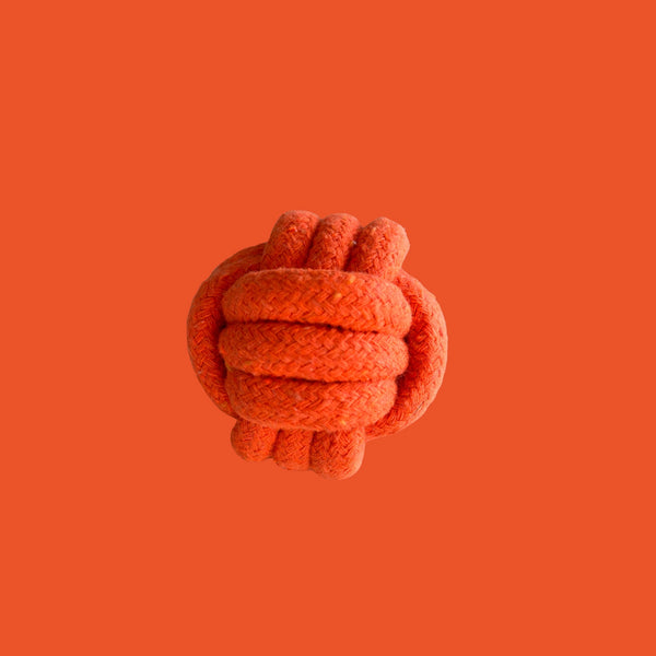 Orange knotted toy on an orange background