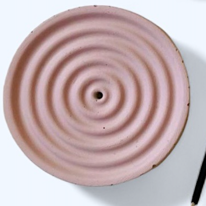 Rose mauve colored  ceramic incense with concentric circular design on a white background