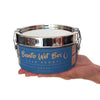 Hand holding round bento box with blue label