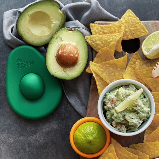 Silicone avocado hugger shown next to leftover cut avocados implied they were used to make the guacamole also pictured next to tortilla chips