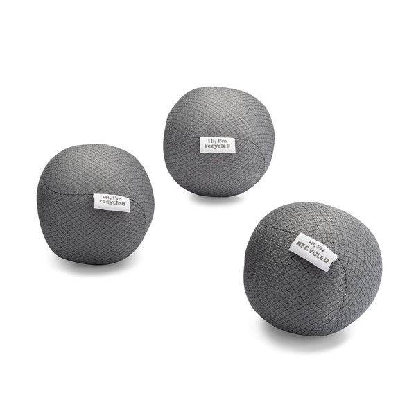 three gray dryer balls made from recycled water bottles. each has a tag on it that says "hi I'm recycled". on a white background.